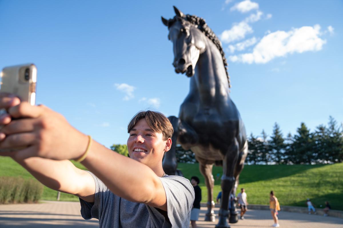 Student takes selfie with Horse Statue at Frederik Meijer Gardens