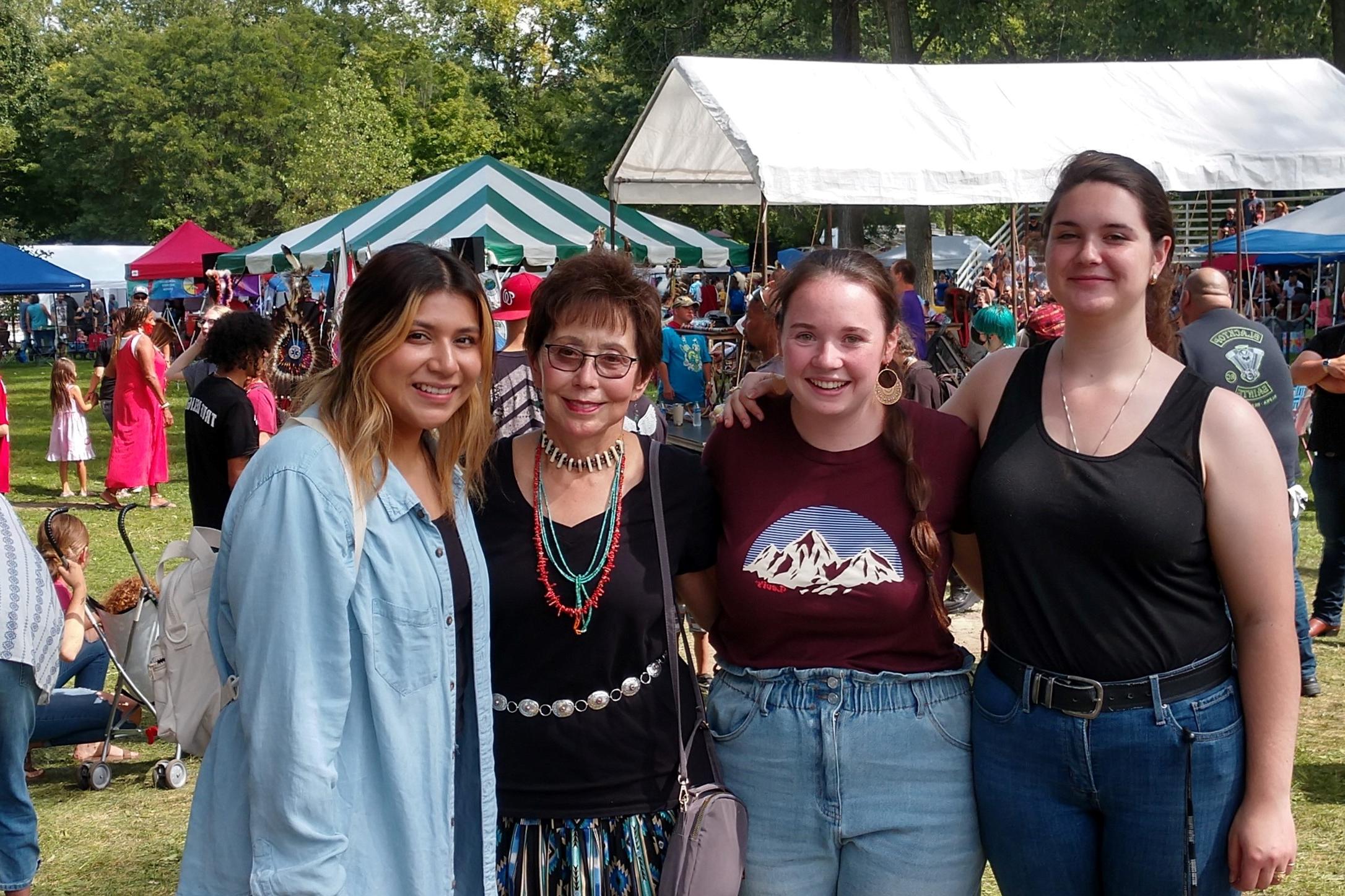 students with professor at powwow